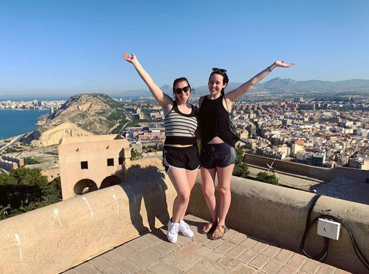 Two people posing in front of a cityscape